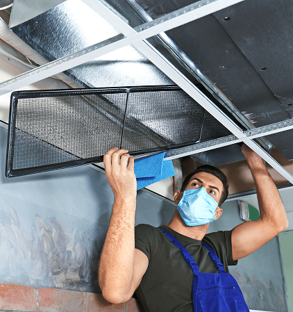male technician cleaning industrial air conditioner indoors 1